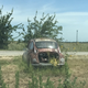 The entrance is marked appropriately with the husk of a Subaru 360.